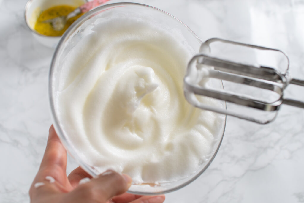 卵白に塩少々を加えて泡立て、しっかりとしたメレンゲを作る。