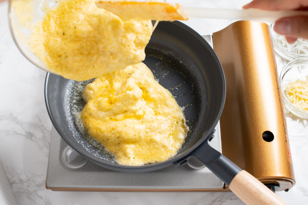 メレンゲをプライパンに流し入れ、片側にしらすとチーズを乗せる。