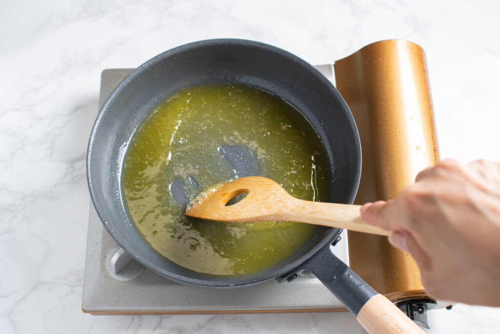 プライパンにオリーブオイルとパスタのゆで汁を加え加熱する。